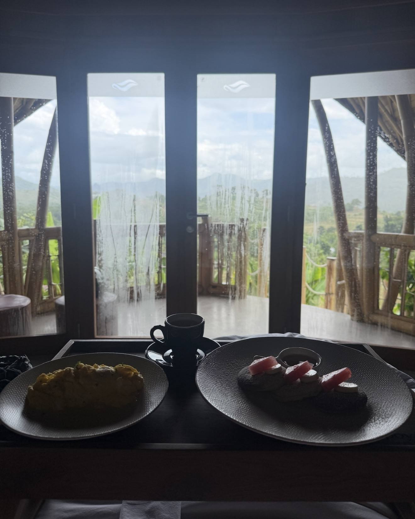 Breakfast plates on a table facing a bamboo grove