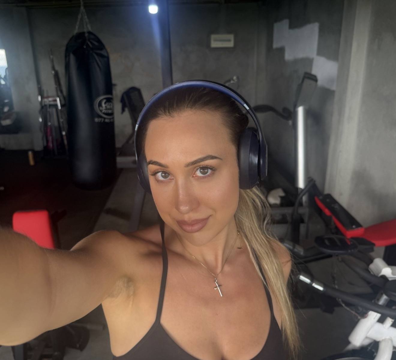 Lauren in headphones at an open-air island gym