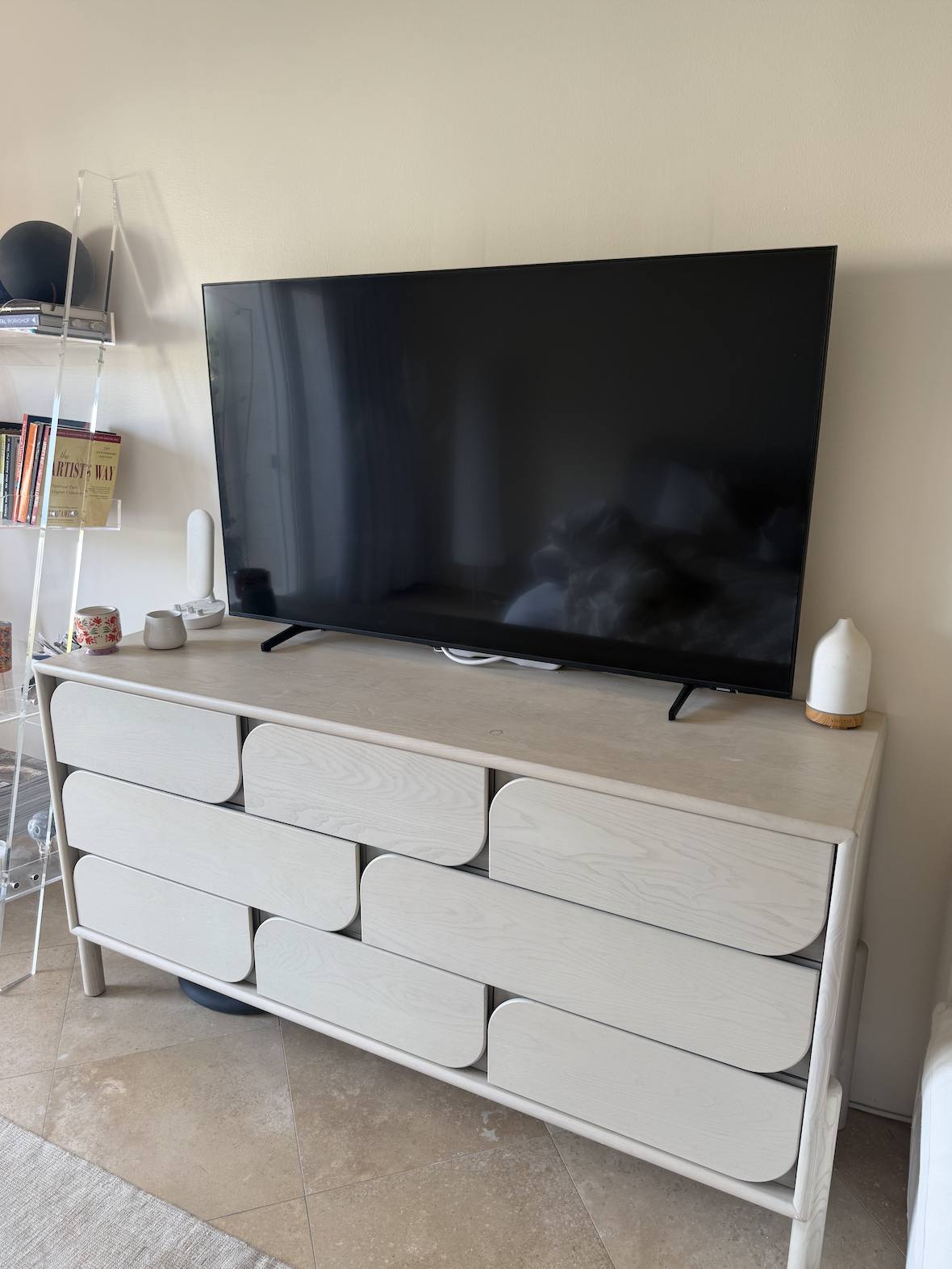 A ribbed cream dresser with the television on top