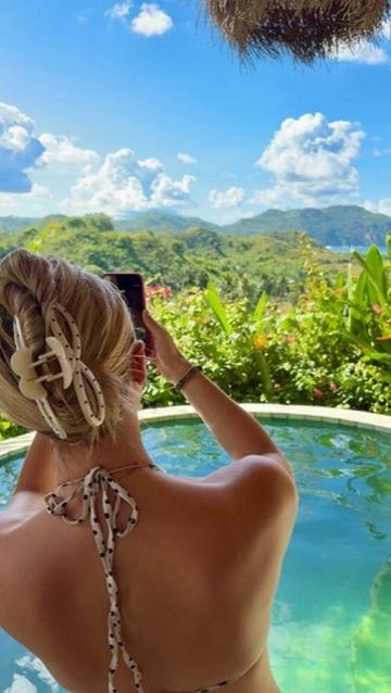 Taking a photograph from the edge of a hillside pool