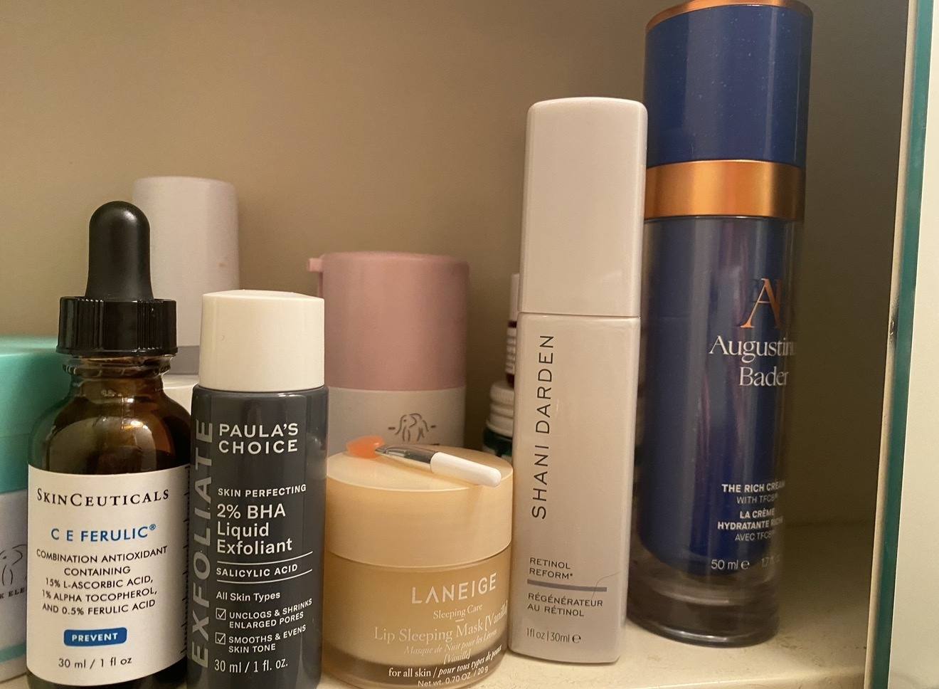 A bathroom shelf: SkinCeuticals C E Ferulic, Paula’s Choice 2% BHA, a Laneige lip mask, Shani Darden Retinol Reform and Augustinus Bader The Rich Cream