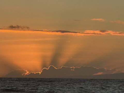 Sun rays breaking through clouds over the sea