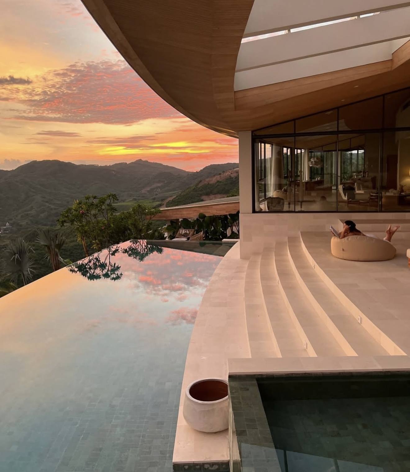 A villa pool at sunset, steps down into the water